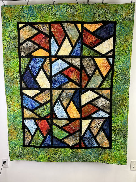 batik quilt with stain glass blocks with green border